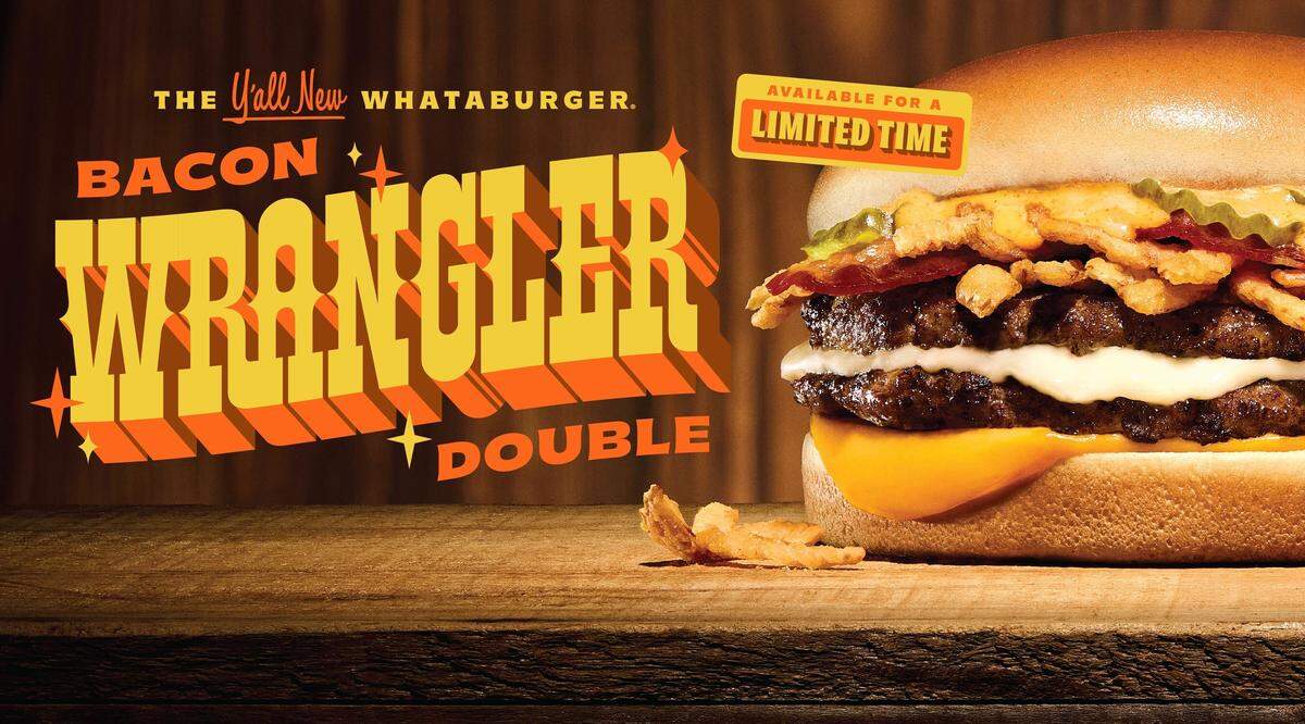 Promotional image for the Whataburger Bacon Wrangler Double. A close-up of the burger shows two beef patties, melted Monterey Jack and American cheese, crispy onion strings, bacon, and chipotle aioli on a toasted bun. Bold Western-style text reads ‘The Y’all New Whataburger Bacon Wrangler Double’ with a banner that says ‘Available for a Limited Time