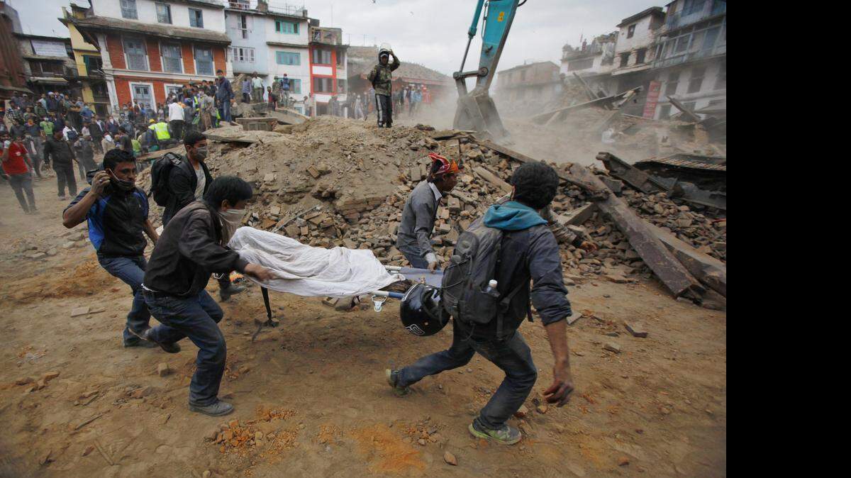 
Volunteers carry the body of a victim on a stretcher, recovered from the debris of a building that collapsed after an earthquake in Kathmandu, Nepal, Saturday.
