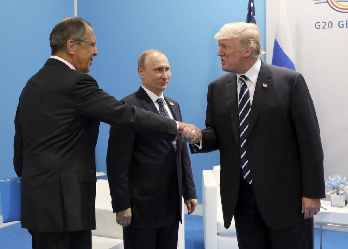 U.S. President Donald Trump, right, greets Russian Foreign Minister Sergey Lavrov, left, prior lto his talks with Russian President Vladimir Putin, center, during the G20 summit in Hamburg Germany, Friday July 7, 2017.
