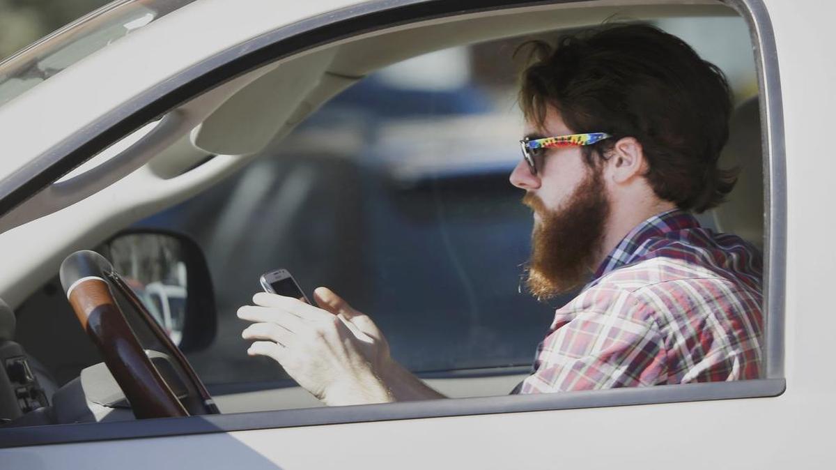 Texting while driving is one of countless proposals filed by Texas lawmakers this year. In this 2013 photo, a man used his cell phone as he driove through traffic in Dallas.