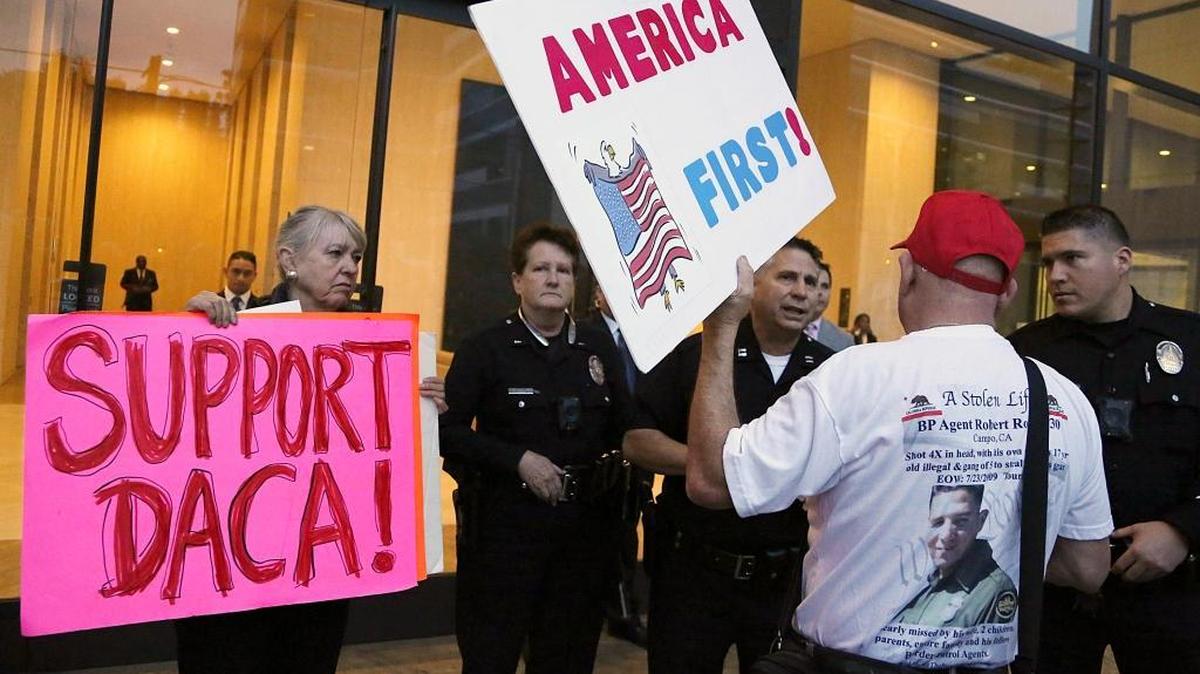 A supporter of President Donald Trump challenges police officers and a Deferred Action for Childhood Arrivals (DACA) program during a rally outside the office of California Democratic Sen. Dianne Feinstein in Los Angeles.