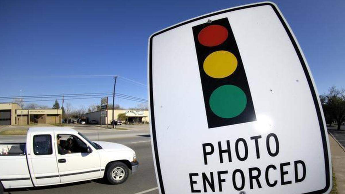 
A sign warns drivers that there are red light cameras ahead. 
