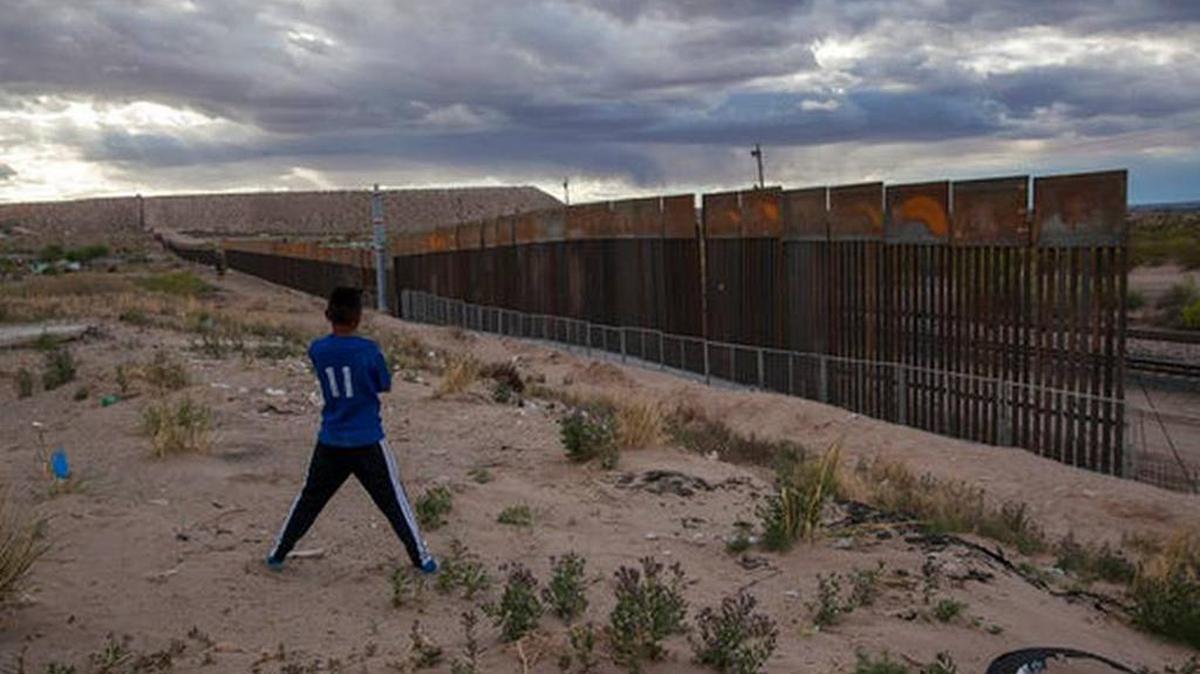 In this March 29, 2017, file photo, a youth looks at a new, taller fence being built along U.S.-Mexico border, replacing the shorter, gray metal fence in front of it, in the Anapra neighborhood of Ciudad Juarez, Mexico, across the border from Sunland Park, New Mexico.