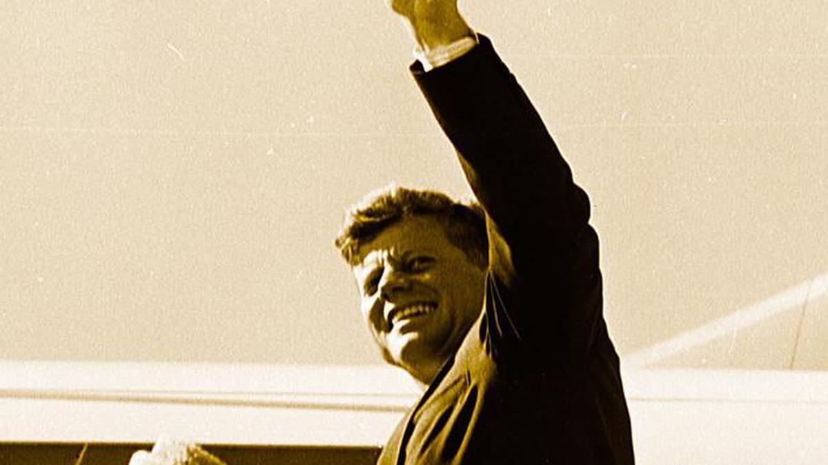 Pres. John F. Kennedy and wife Jackie enter Air Force One to fly from Fort Worth to Dallas; JFK waves to crowd at Carswell AFB on Nov. 22, 1963.