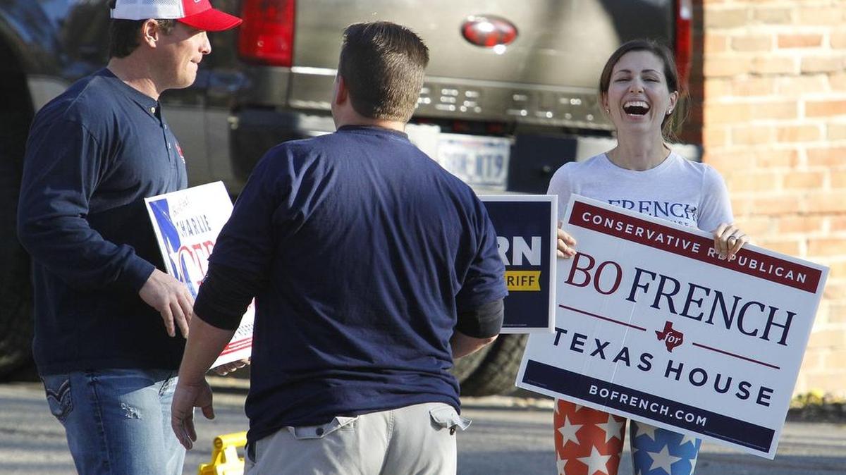Candidate volunteers Ryan Zelazny, (supporting Charlie Geren), Sean Mullins (supporting Bill Waybourn) and Sheridan French (supporting husband Bo French) share a laugh while greeting voters outside of the Westover Hills Town Hall during the March 2016 primary.