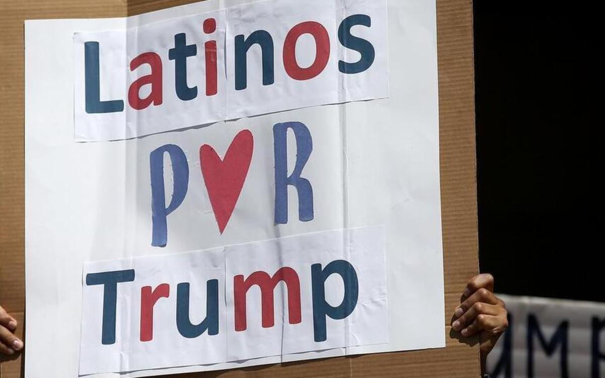 A man hoists a sign during a rally of about 100 of presidential candidate Donald Trump’s Latino supporters outside Anaheim City Hall on Sunday, Aug. 28, 2016. Speakers called for limits on immigration to the United States by building a wall between the U.S. and Mexico.