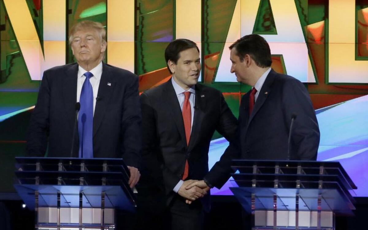 Donald Trump pauses as Sen. Marco Rubio, center and Sen. Ted Cruz shake hands during a break in the debate.