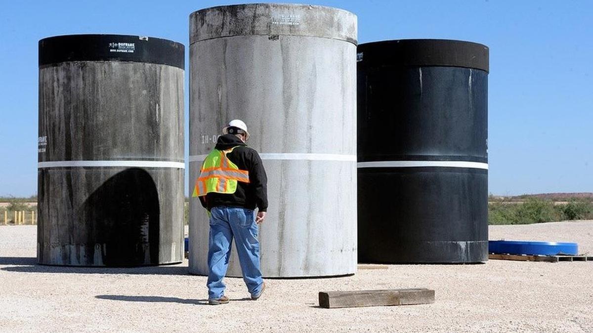 John Ward, operations project task manager at Waste Control Specialists’ facility near Andrews, Texas, is pictured in 2017 inspecting concrete canisters that will house drums of nuclear waste.