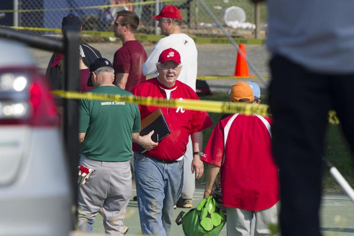 U.S. Rep. Joe Barton, R-Texas, center, and other members of the Republican Congressional softball team, stand behind police tape of the scene of a multiple shooting in Alexandria, Va., Wednesday.