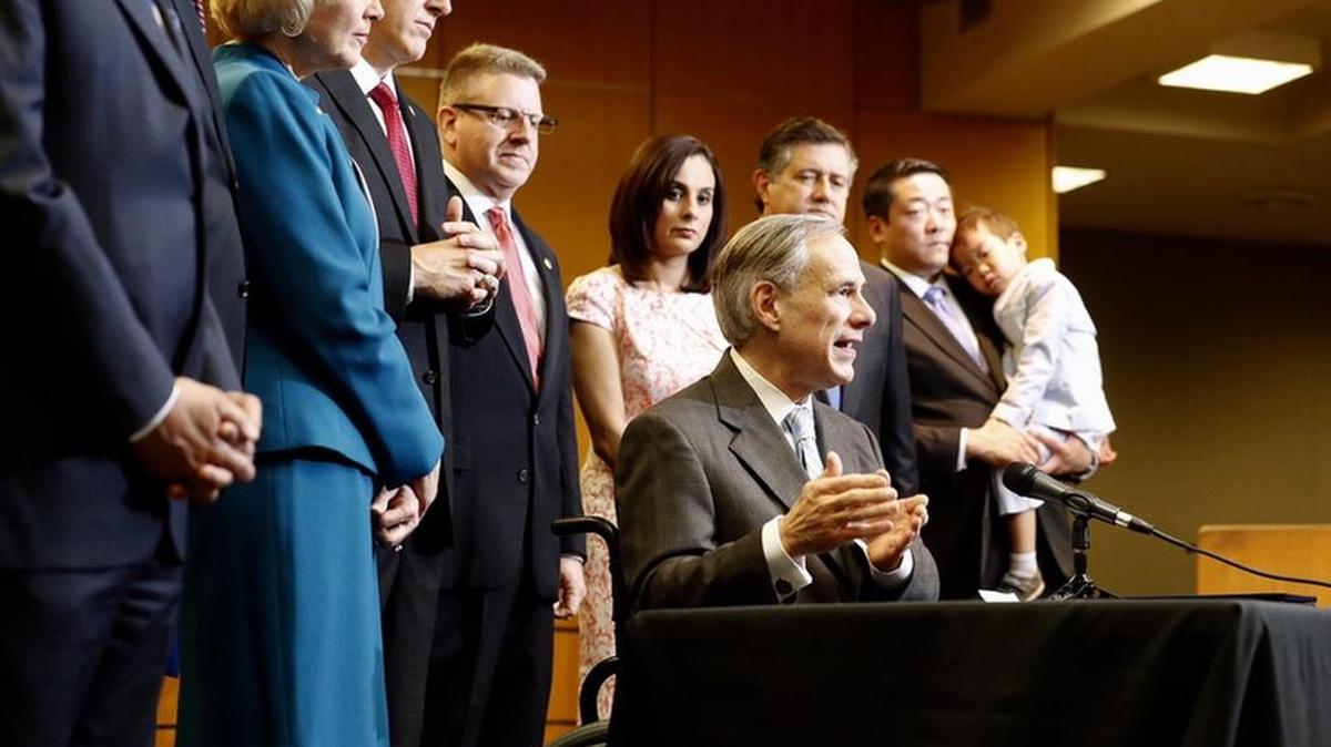Gov. Greg Abbott signs four bills aimed at reforming Child Protective Services, at the Texas Department of Family and Protective Services headquarters in Austin on Wednesday.