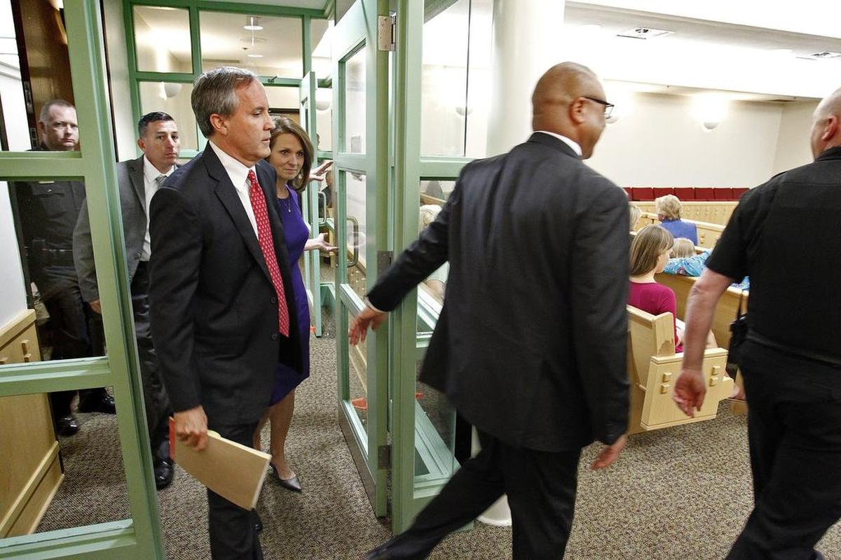 With a heavy security detail, Texas Attorney General Ken Paxton arrives in court in 2015. Paxton appeared for arraignment in State District Judge George Gallagher's court in Fort Worth. He had been indicted on two felony counts of securities fraud and one count of failing to register with the State Securities Board.