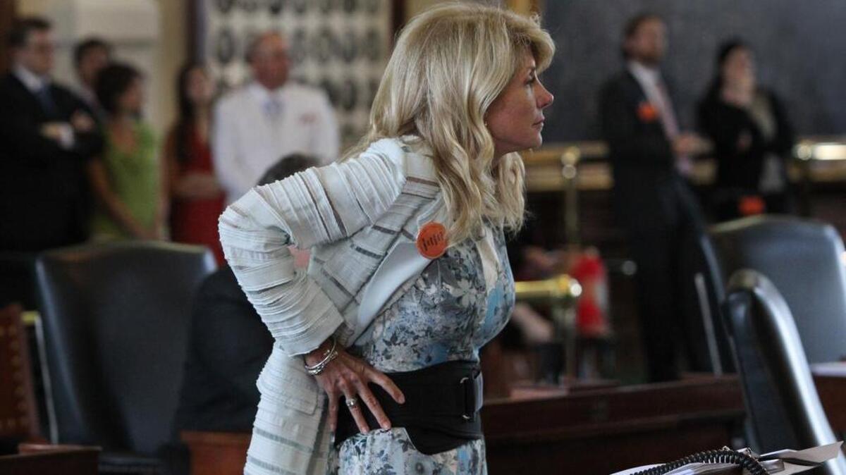 File: State Senator Wendy Davis dons a back support belt given to her by colleagues during the seventh hour of filibustering during the final day of the legislative special session, as the Senate considers an abortion bills on Tuesday, June 25, 2013. The showcase bill passed that day has a date before the U.S. Supreme Court on Wednesday. (Louis DeLuca/Dallas Morning News)