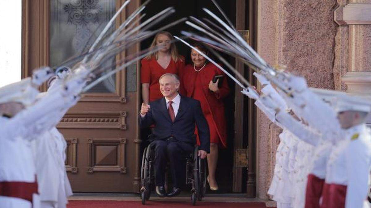 
Texas Gov.-elect Greg Abbott arrives for his inauguration with his wife, Cecilia, right, and daughter Audrey on Tuesday as the Ross Volunteers of Texas A&M University form a saber arch. 
