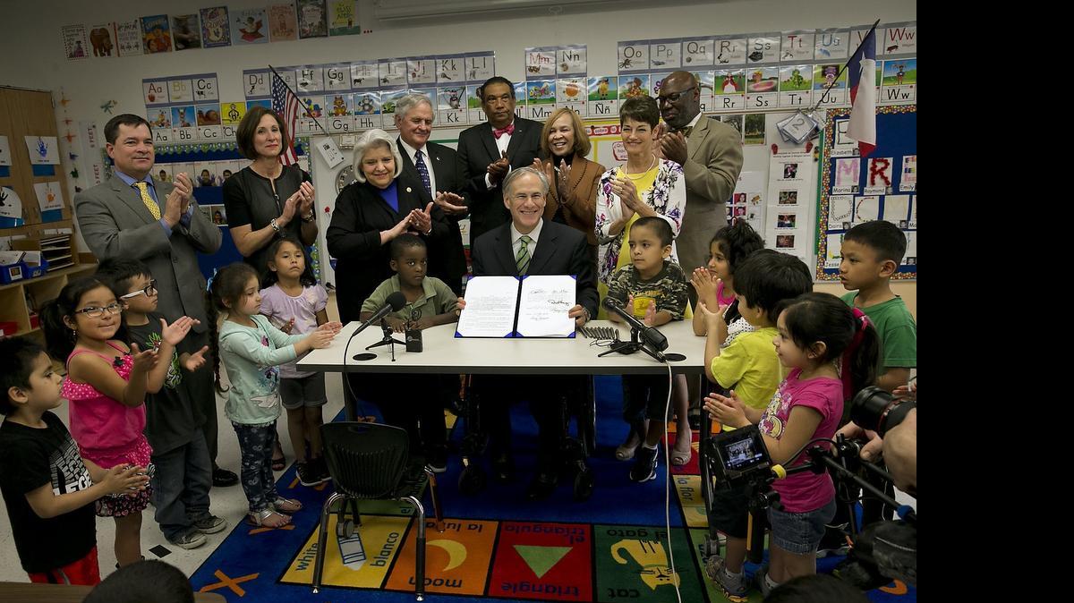 
Gov. Greg Abbott poses for a photo after signing a pre-K bill at an Austin early-childhood school. 


