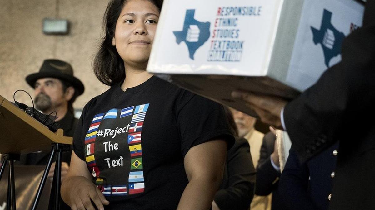 Carolina Hernandez, a student in the Houston school district, spoke during a news conference at the Texas Education Agency on Tuesday about a proposed Mexican-American studies textbook that educators and activists have criticized. As Hernandez spoke, she glanced at a box holding 15,000 petitions against the textbook.