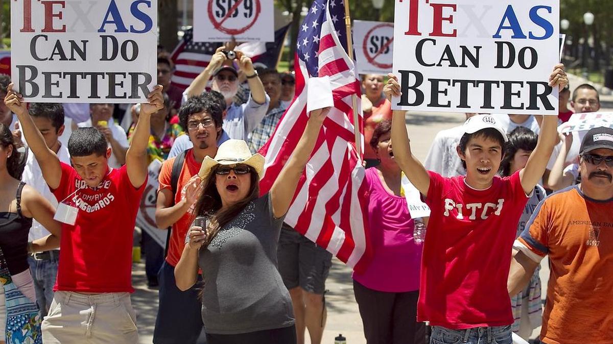 File: A large crowd gathers in the heat of the day June 20, 2011, on the south steps of the state Capitol to protest the Sanctuary Cities bill revived in the legislative special session and to rally against immigration bill proposals like SB9, in Austin. The fight in Austin continues to play out in 2015.