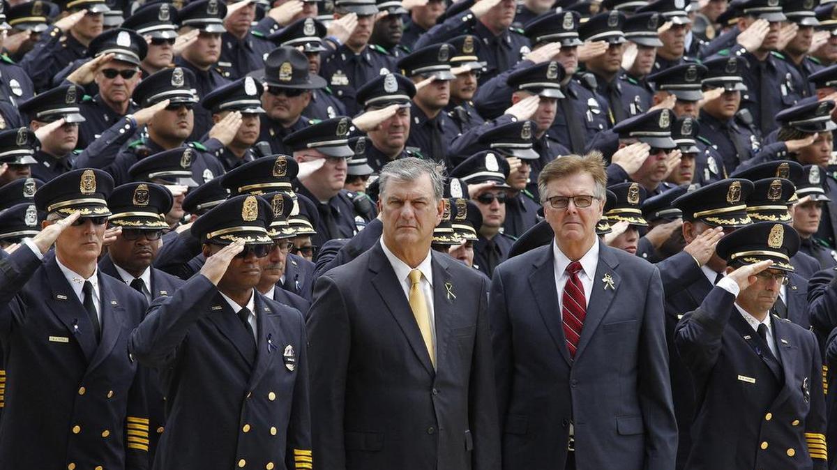 Then-Dallas Police Chief David Brown, Dallas mayor Mike Rawlings and Texas Lt. Gov.Dan Patrick stand at attention with hundreds of officers July 15 for the funeral service of Dallas Police officer Michael Krol.
