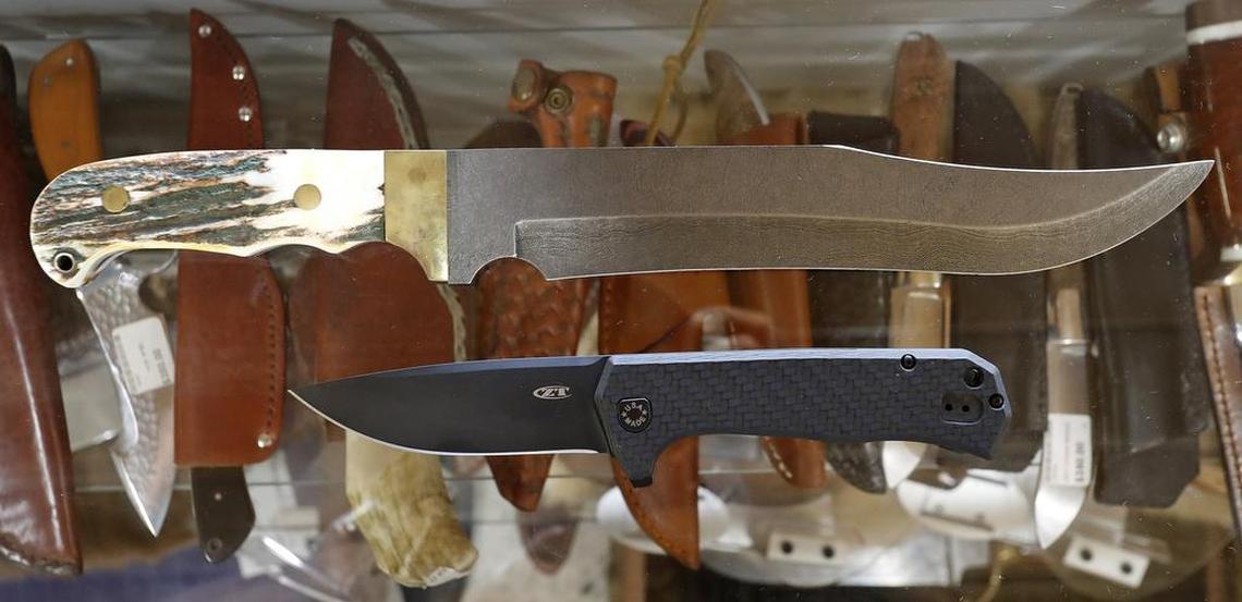 A currently legal everyday carry folding knife (bottom) under one of the store's larger Bowie knives (top). The staff at House of Blades in west Fort Worth, show some of the currently-legal knives, as well as some larger items that will be legal in Texas as of September 1.