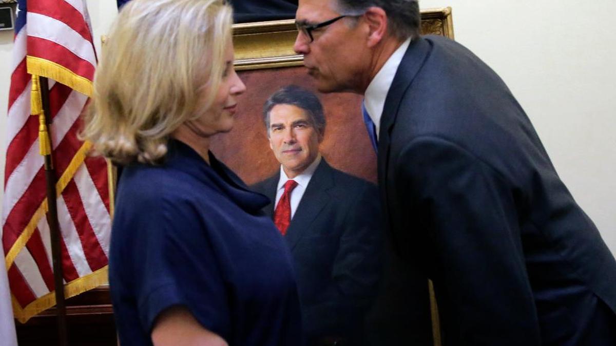 Live: Former Texas Gov. Rick Perry, right, leans to kiss his wife Anita following a ceremony for the unveiling of his official portrait in the Capitol rotunda, Friday, May 6, 2016, in Austin, Texas. (AP Photo/Eric Gay)