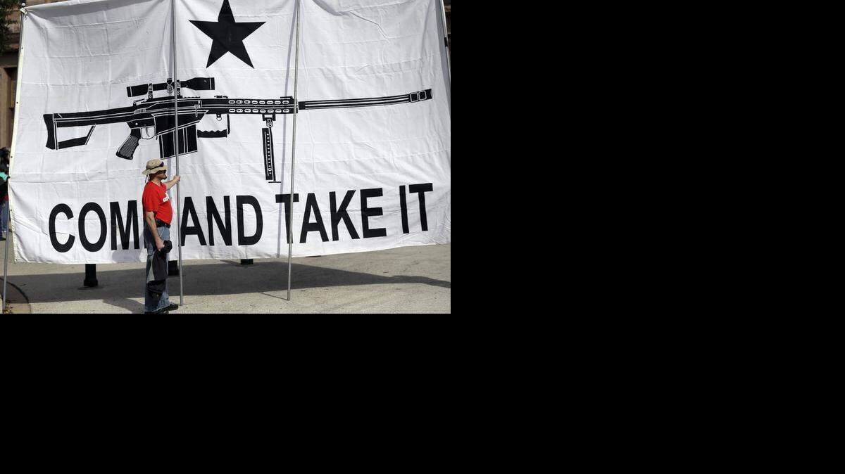 
A demonstrator helps hold a large "Come and Take It" banner at a rally in support of open carry gun laws at the Capitol, Monday, Jan. 26, 2015, in Austin. (AP Photo/Eric Gay)
