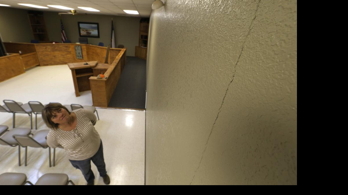 
City secretary Becky Young looks at the cracks that have developed in the floor and wall of the municipal court room in Reno in 2014.. Some people believe it is related to the rash of earthquakes reported in the area.
