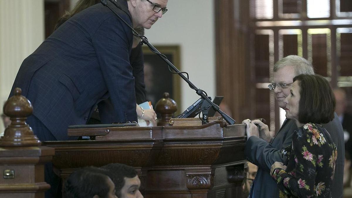 Lt. Gov. Dan Patrick, who has made Senate Bill 6, prohibiting transgender-friendly bathrooms, a top priority for the senate, speaks with Republican state Sen. Lois Kolkhorst, author of the bill, as she presents it on the floor of the senate for debate at the state capitol in Austin, Texas. (Ralph Barrera/Austin American-Statesman via AP)