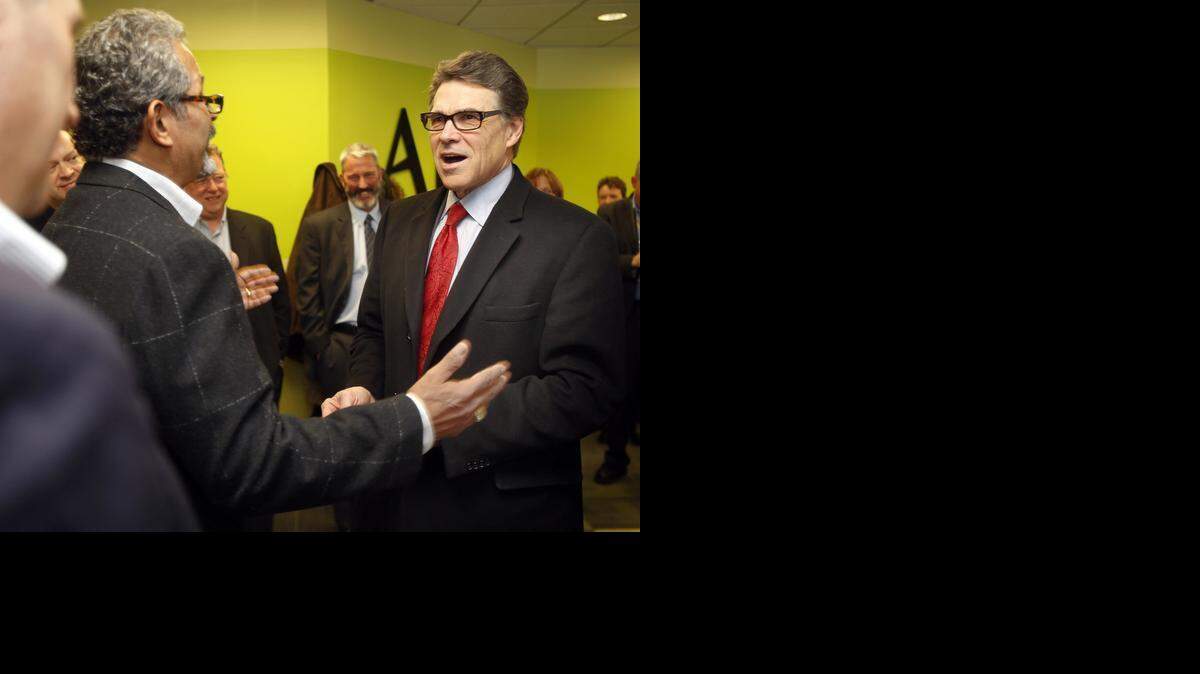 
Former Texas Gov. Rick Perry talks to Jose T Morales before meeting with area business leaders, on Feb. 11, in Bedford, N.H. The former 2012 presidential hopeful told them he’s “just warming up” and carefully preparing for a possible presidential campaign.
