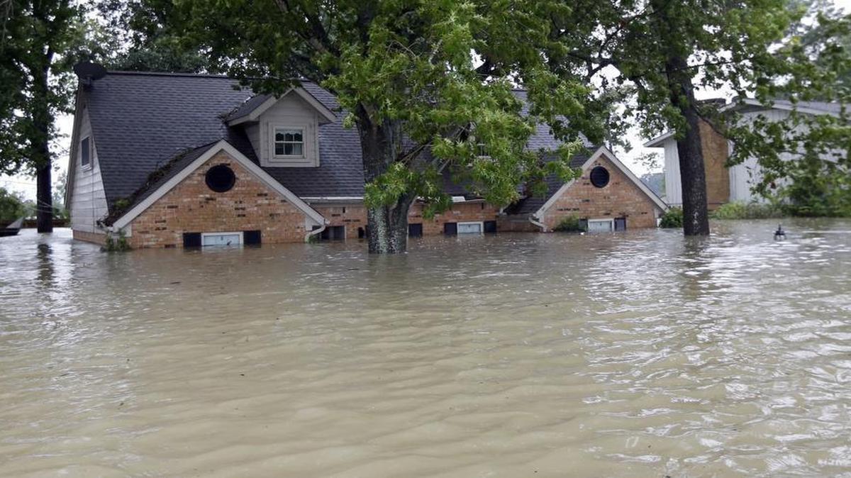 A home is consumed by floodwaters from Tropical Storm Harvey on Monday in Spring.
