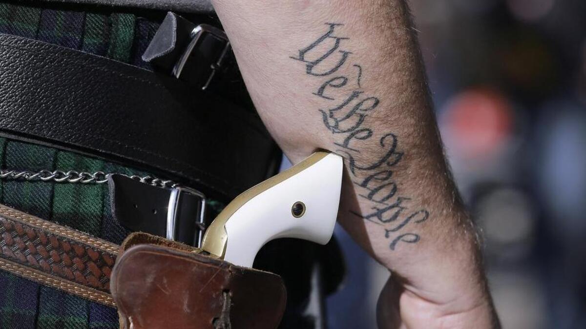 In this Jan. 26, 2015, file photo, Scott Smith, a supporter of open carry gun laws, wears a pistol as he prepares for a rally in support of open carry gun laws at the Capitol, in Austin, Texas. Despite its reputation as the trigger-happy heart of American gun culture, Texas is late to the open carry party, at least when it comes to handguns. On New Year’s Day, it’ll become the 45th state to legalize carrying a pistol in plain sight.