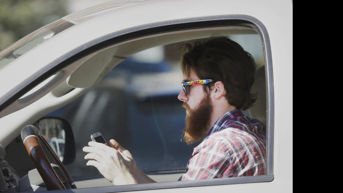 
In this Feb. 26, 2013 file photo, a man uses his cell phone as he drives through traffic in Dallas. 
