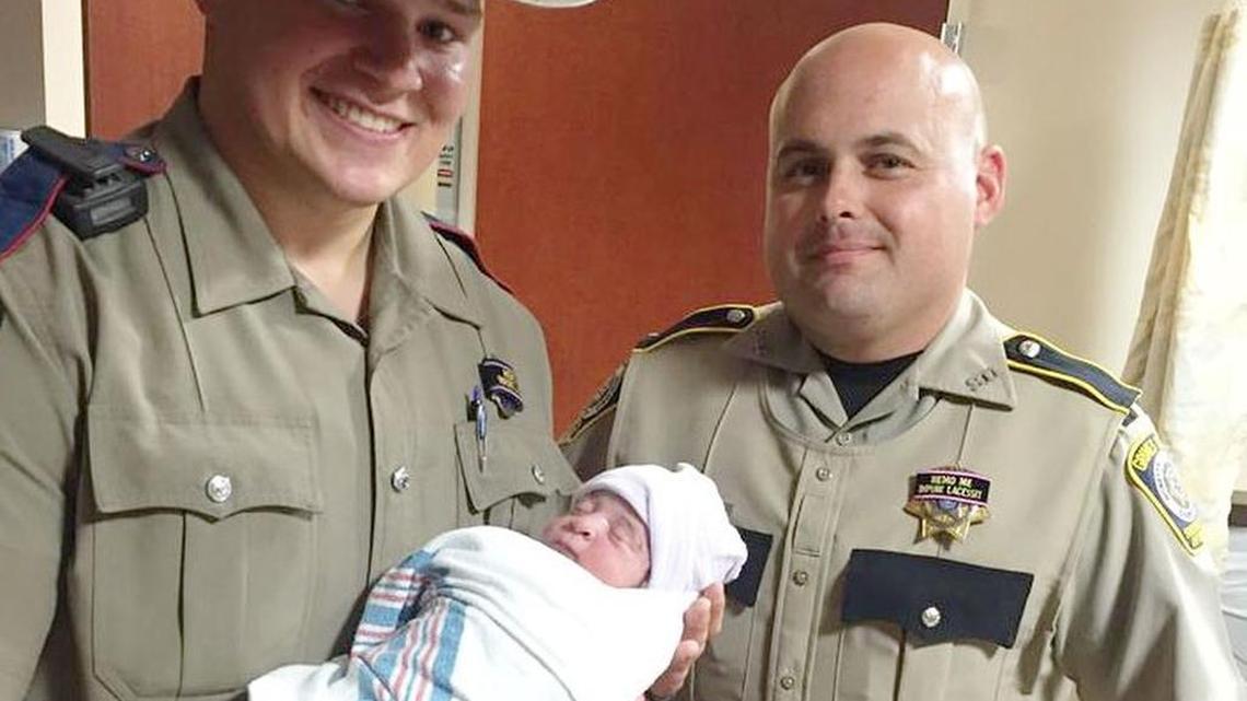 Texas State Trooper Dylan Duke and Grimes County Sheriff’s Deputy Steven Siracusa with Oscar Jr., the baby they helped deliver Saturday.