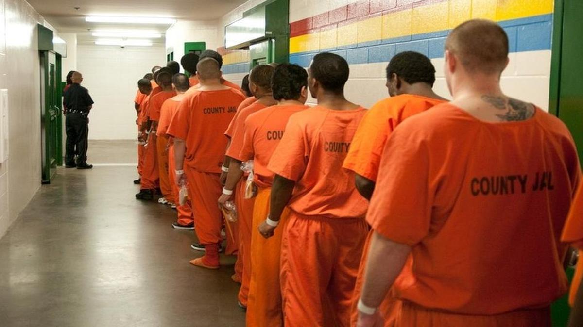 Inmates walk by in the Harris County Jail in 2011.
