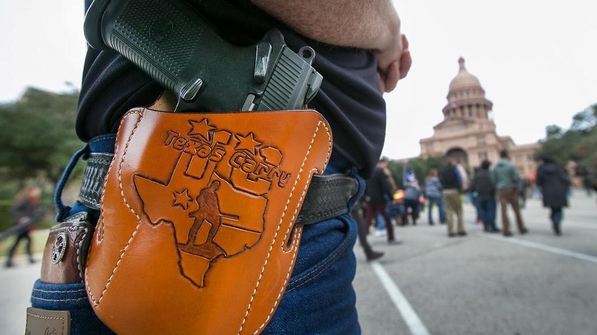 Terry Holcomb, Executive Director of Texas Carry happily displays his customized holster as he walks to the Capitol for a rally in Austin on Jan 1, 2016, to celebrate Texas becoming an open carry state.