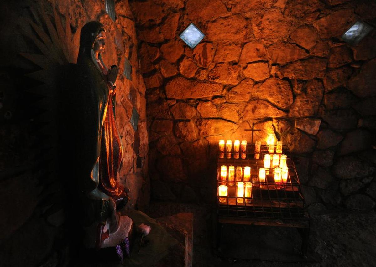 A statue of the Virgin of Guadalupe is illuminated by glass prayer candles outside of Ballinger. The grotto bearing her name is located in a garden about 140 yards from the 99-foot steel cross overlooking the city.