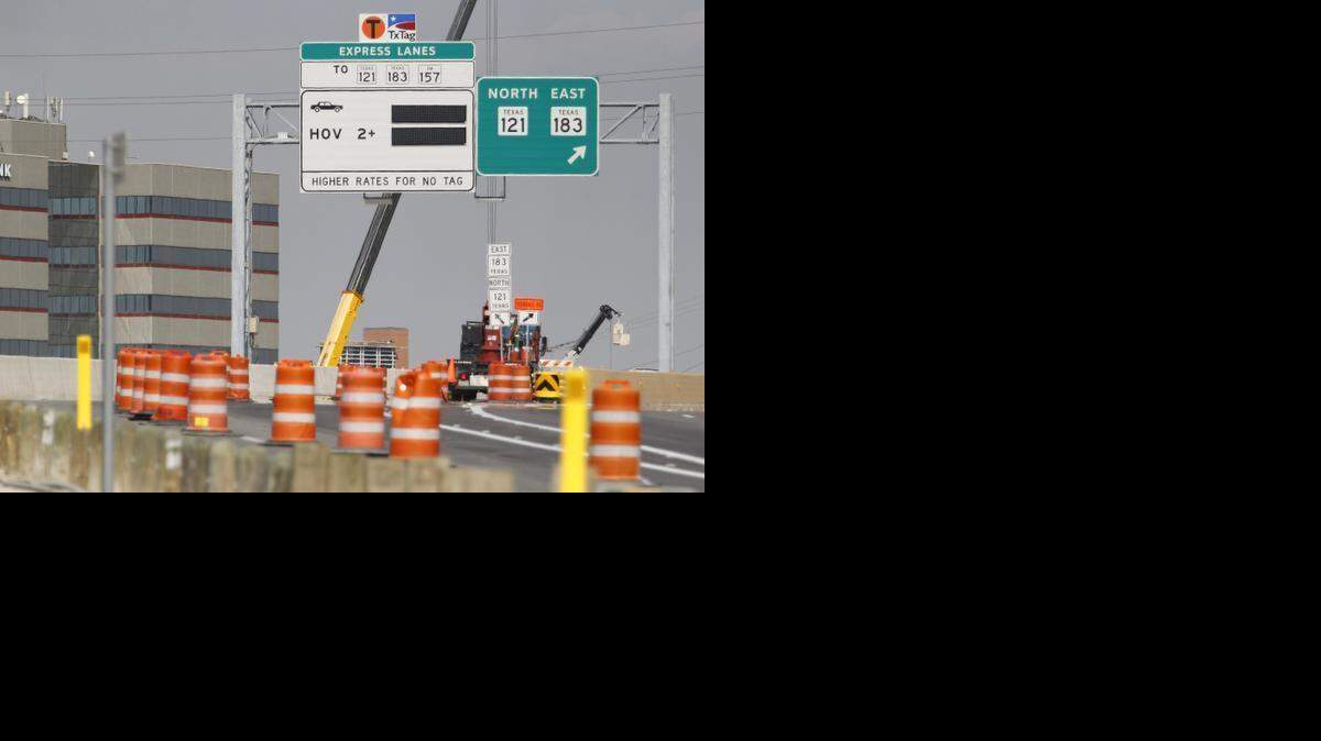 
Workers install signs at the end of the $2.5 billion makeover of North Tarrant Express in September. Two bills that would take some of the money raised from sales taxes on cars and dedicate it to building and fixing state highways passed the Texas Senate on Wednesday. 
