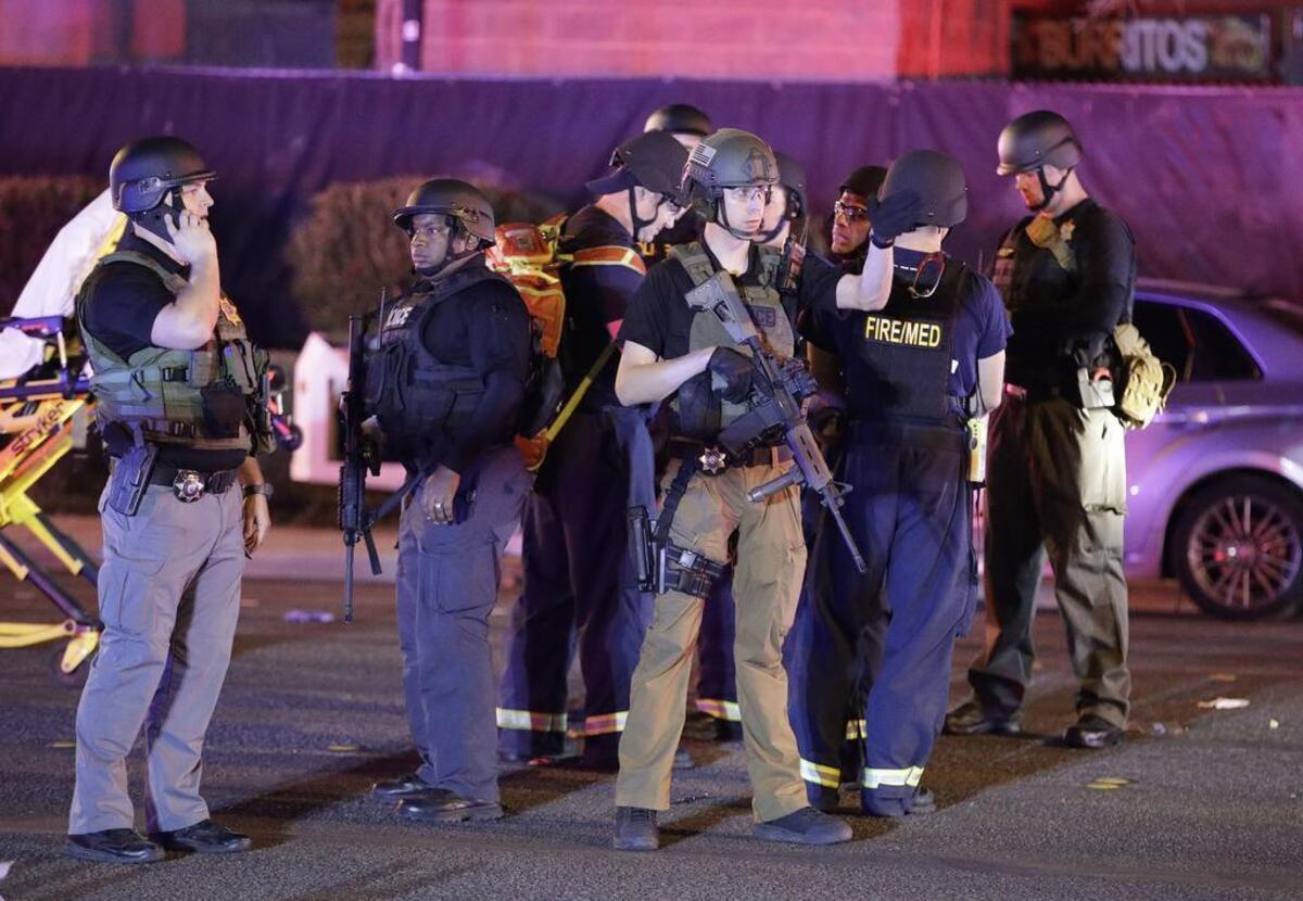Police officers stand at the scene of a mass shooting Sunday evening near the Mandalay Bay resort and casino on the Las Vegas Strip in Las Vegas.