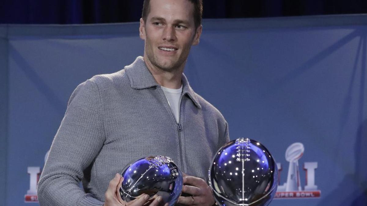 New England Patriots quarterback Tom Brady walks off with his MVP trophy during a news conference Monday in Houston.