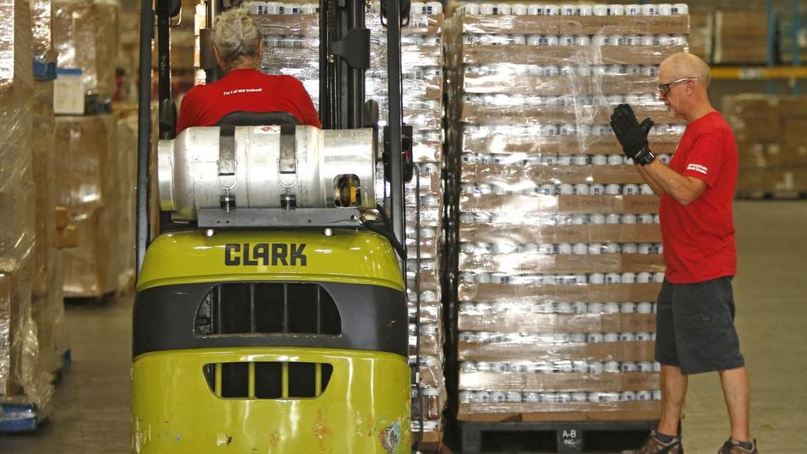 Red Cross volunteer David Hayworth directs forklifts loaded with canned water at the Red Cross Disaster Field Supply Center in Arlington on Wednesday.