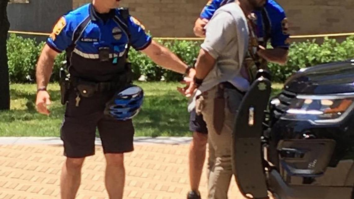 A man wearing a large knife sheath is arrested after a fatal stabbing attack on the University of Texas campus in Austin on Monday.