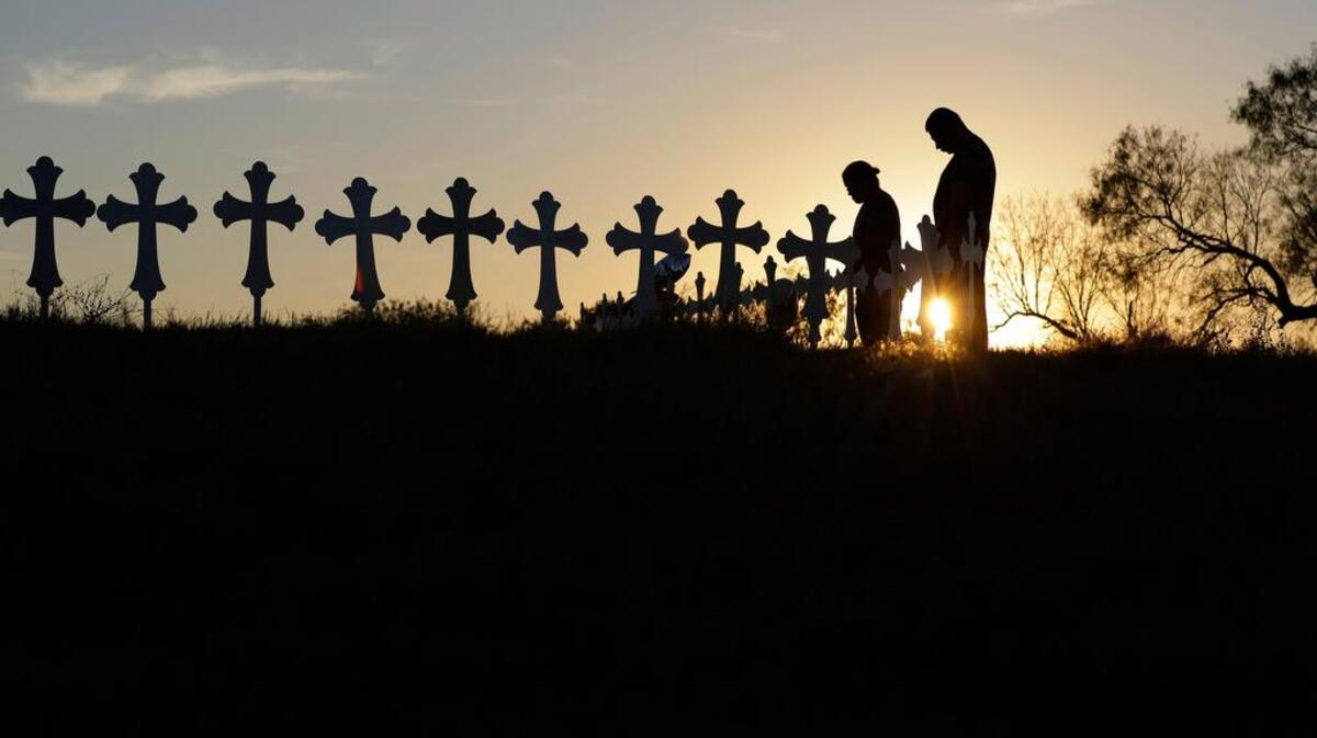 Kenneth and Irene Hernandez pay their respects as they visit a makeshift memorial with crosses placed near the scene of a shooting at the First Baptist Church of Sutherland Springs, Monday, Nov. 6, 2017, in Sutherland Springs, Texas. A man opened fire inside the church in the small South Texas community on Sunday, No. 5, 2017, killing 26.