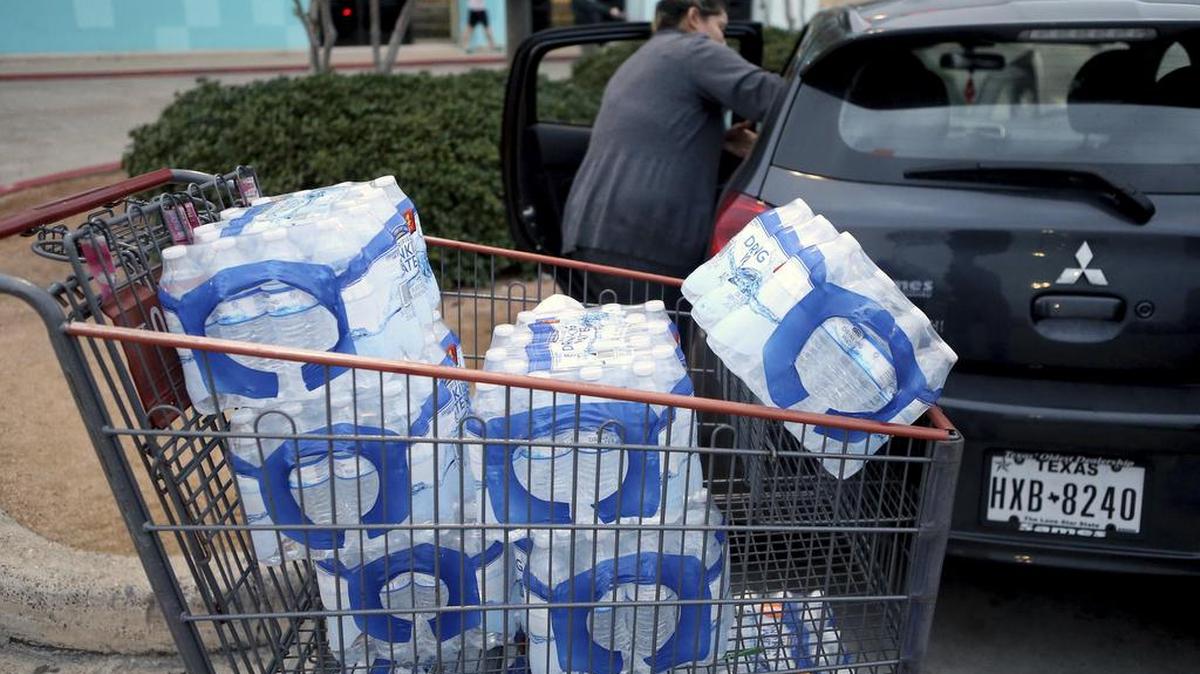 A customer loads her vehicle with bottles of water at an H-E-B store Dec. 15 in Corpus Christi.