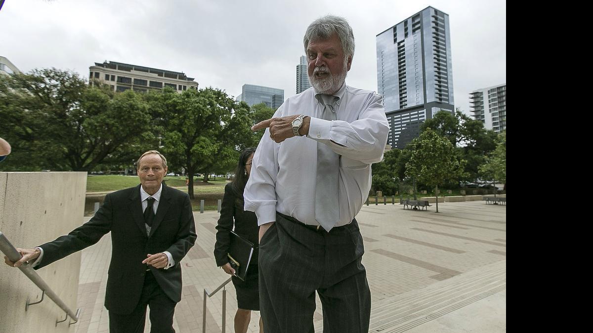 
Williamson County Court-at-Law Judge, Tim Wright, 70, right, defers a question to his attorney Jeff Senter, left, as he reports to the federal courthouse in Austin on April 8. 
