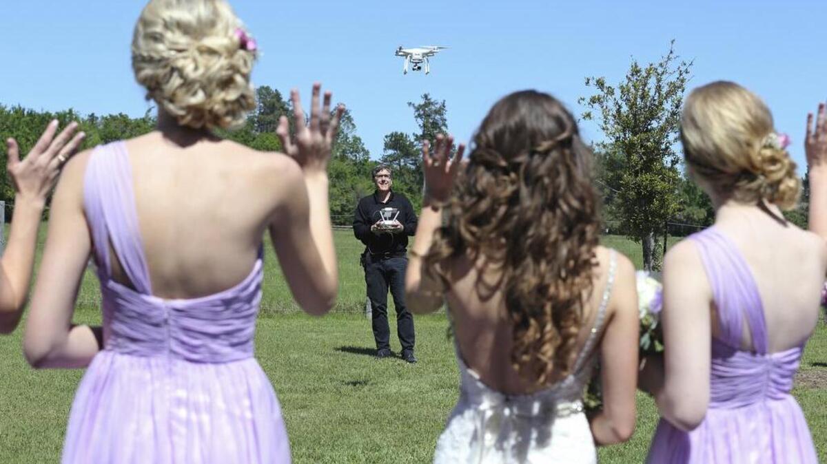 Bridesmaids wave to the drone flown by videographer Coleman Jennings to take footage for a video of the Taylor Jolly-Amy Stark wedding in Montgomery.