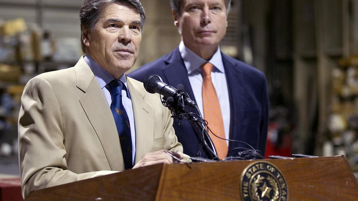 Gov. Rick Perry and Lt. Gov. David Dewhurst visit an Austin glass company on Nov. 13, 2012, to discuss reforms to welfare and unemployment insurance programs. Nearly three years after Texas lawmakers passed a law requiring some applicants for unemployment benefits to pass a drug test, the state has yet to test a single applicant, and it remains unclear when the program will get going.