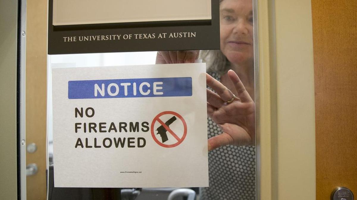 University of Texas at Austin professor Pauline Strong posts a sign prohibiting guns at her office on the first day of the new campus-carry law Aug. 1, 2016.