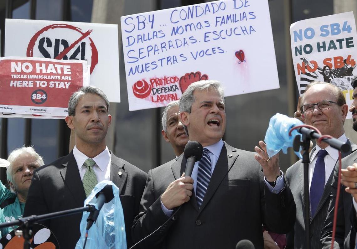 Austin Mayor Steve Adler, center, stands with, San Antonio Mayor Ron Nirenberg, left, as he speaks to protesters at a rally to oppose a new Texas "sanctuary cities" bill that aligns with the president's tougher stance on illegal immigration, Monday in San Antonio, outside of the Federal Courthouse.