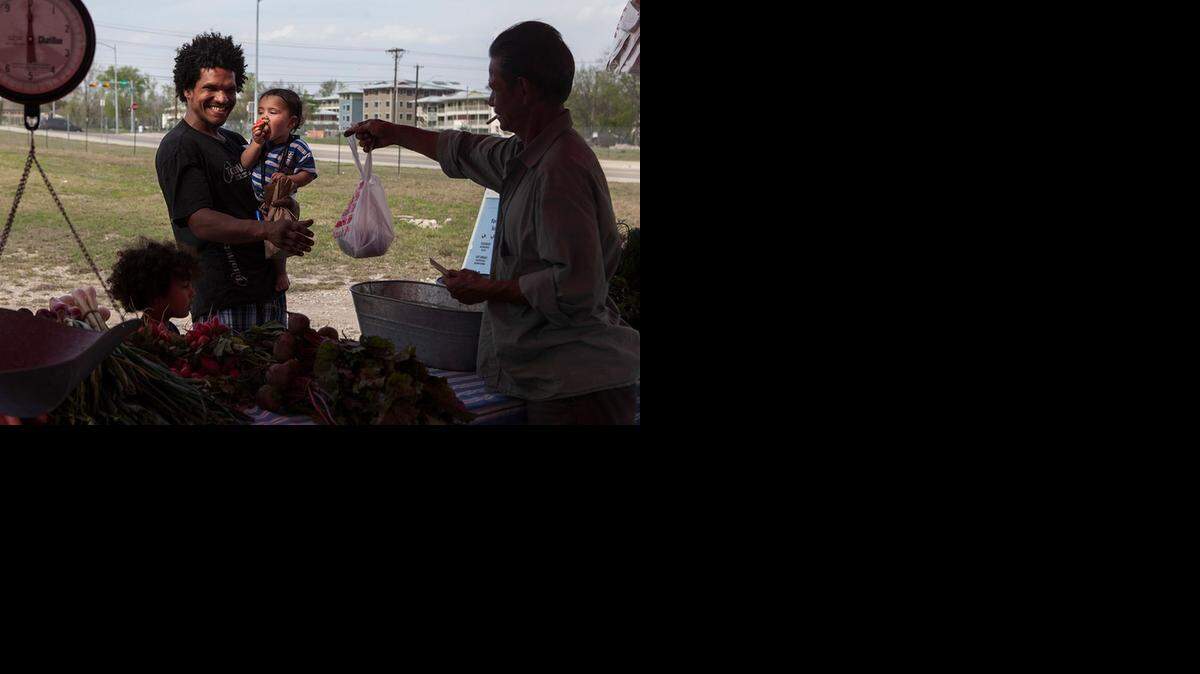 
Tiger Whitehead and his children Logic and Domnick, who used SNAP and the the Sustainable Food Center Farmer's Market double dollars coupons, shopping at the Farmer's Market at 2835 East MLK Blvd. in Austin on March 19, 2013.
