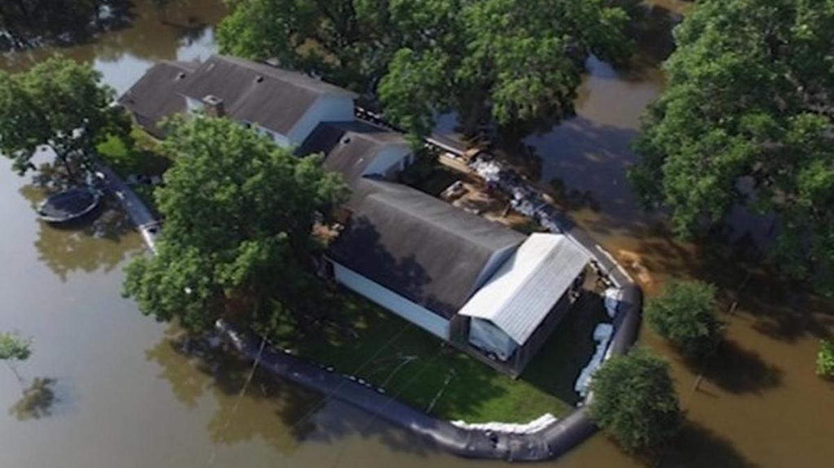 The AquaDam surrounds Randy Wagner's home as floodwaters continue to rise.