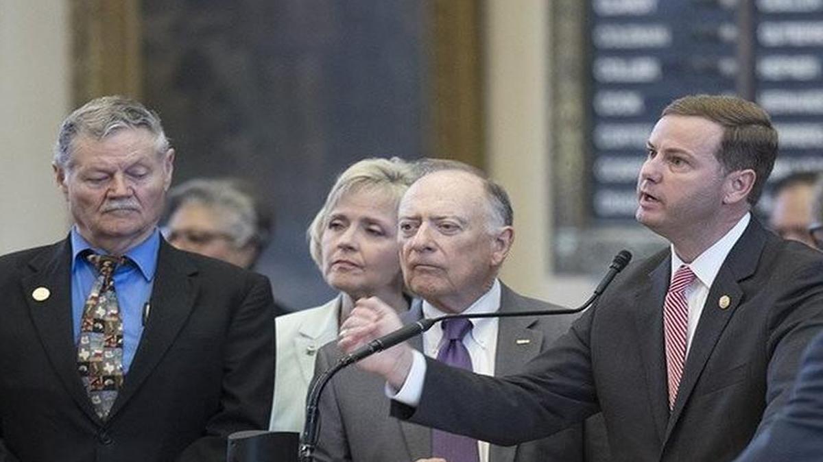 Rep. Trent Ashby, R-Lufkin, speaks on House Bill 20 surrounded by colleagues on the House floor Tuesday.