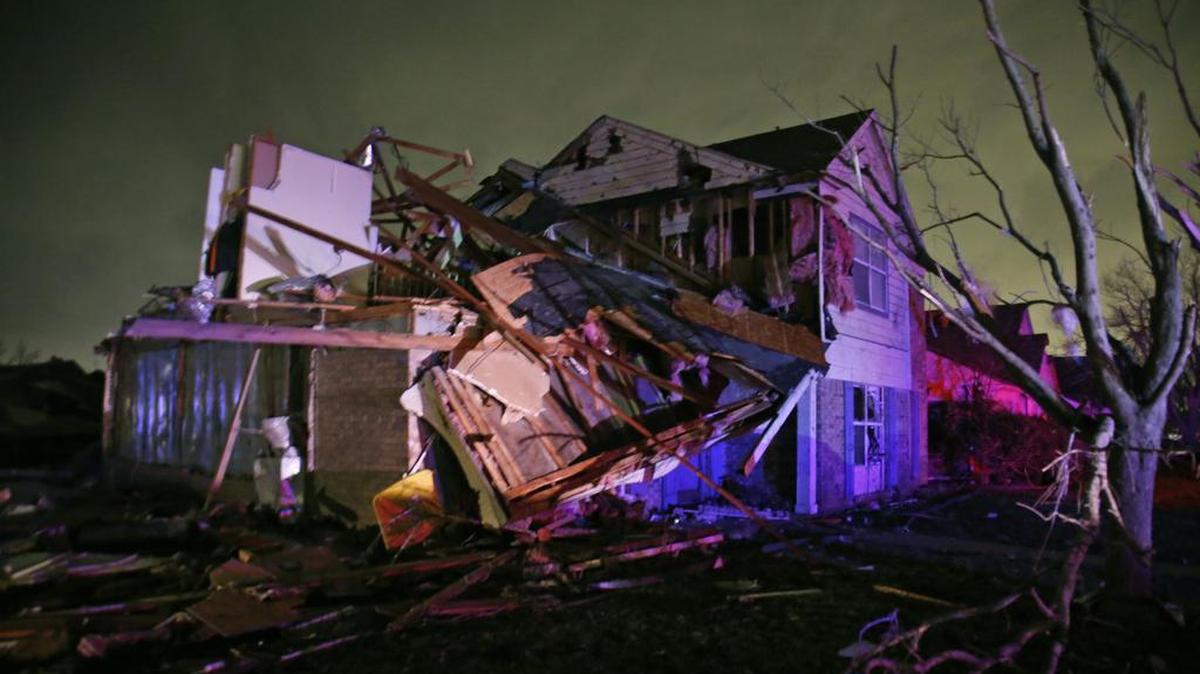 Debris lies on the ground near a home that was heavily damaged by a tornado in Rowlett.